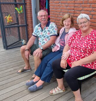 Drie mensen zitten samen op een bank